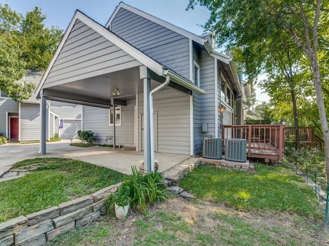 exterior space featuring central air condition unit, a carport, and a deck