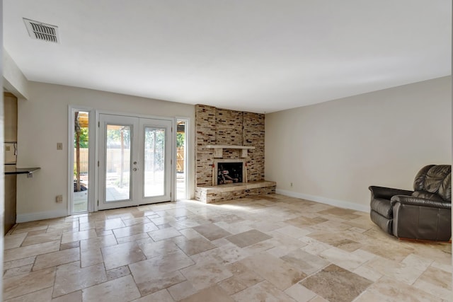 unfurnished living room with french doors and a brick fireplace