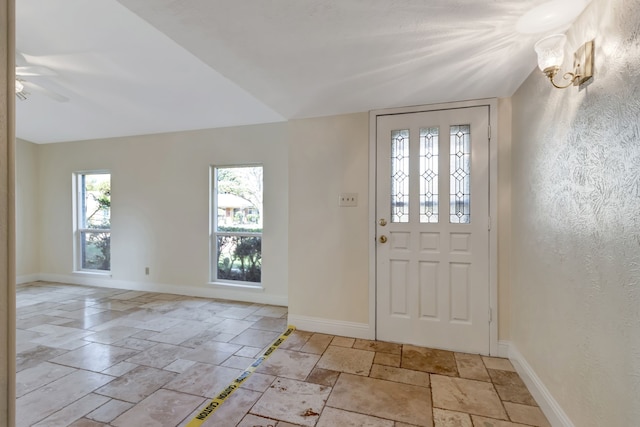 foyer entrance featuring ceiling fan and vaulted ceiling