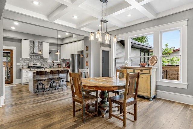 dining space featuring beam ceiling, sink, coffered ceiling, and dark hardwood / wood-style flooring