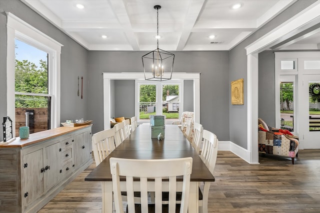 dining area featuring beam ceiling, coffered ceiling, dark wood-type flooring, and a chandelier