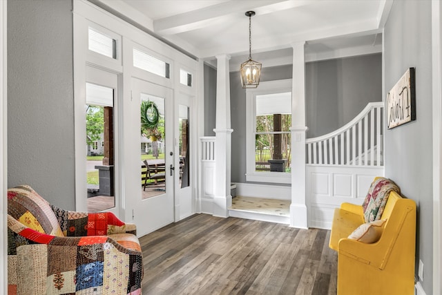 doorway with a healthy amount of sunlight, beamed ceiling, ornate columns, and dark hardwood / wood-style flooring