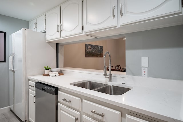 kitchen with appliances with stainless steel finishes, sink, and white cabinets