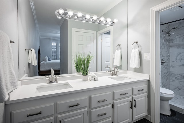 bathroom with vanity, tiled shower, crown molding, and toilet