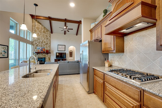 kitchen with light stone countertops, appliances with stainless steel finishes, vaulted ceiling with beams, sink, and premium range hood