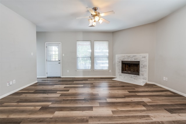 unfurnished living room featuring dark wood-type flooring and ceiling fan