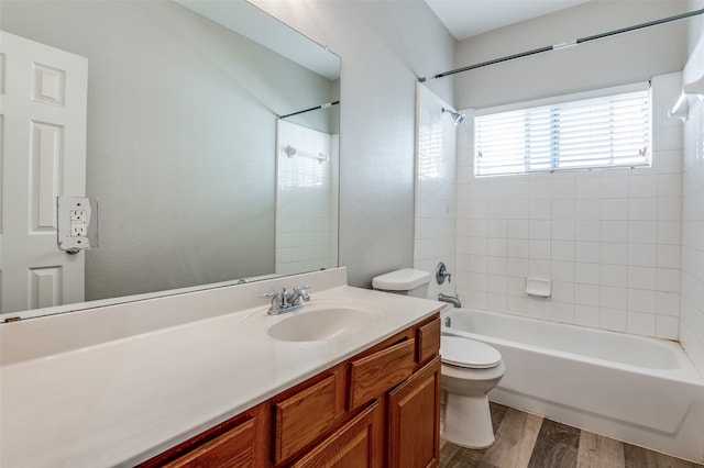 full bathroom featuring vanity, toilet, wood-type flooring, and tiled shower / bath