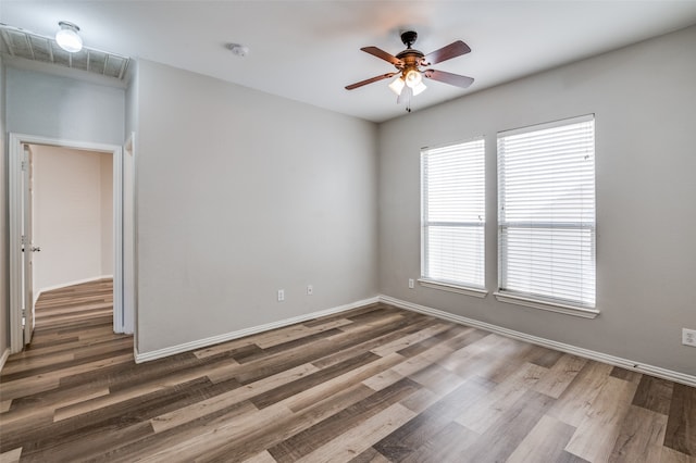 spare room with dark wood-type flooring and ceiling fan