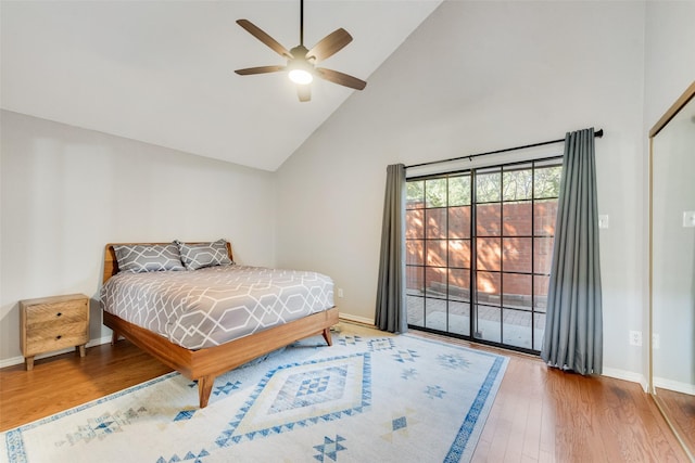 bedroom with hardwood / wood-style floors, high vaulted ceiling, and ceiling fan