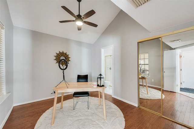 home office featuring dark hardwood / wood-style floors, vaulted ceiling, and ceiling fan