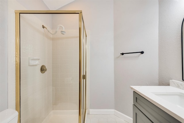 bathroom with tile patterned floors, vanity, toilet, and a shower with door