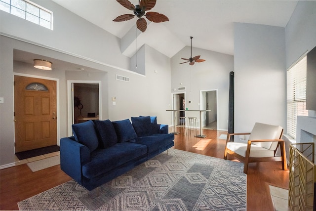 living room featuring wood-type flooring and high vaulted ceiling