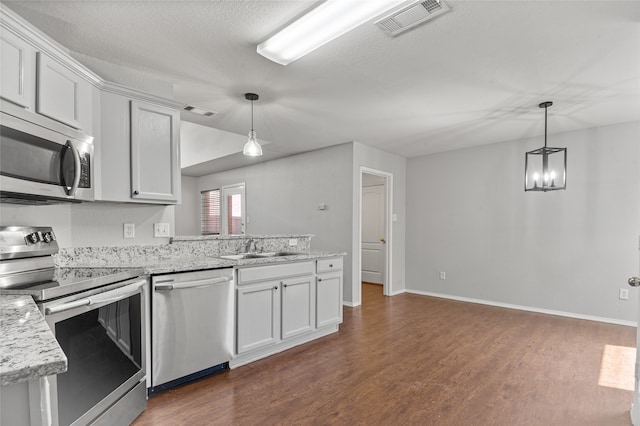 kitchen with dark wood-type flooring, appliances with stainless steel finishes, and white cabinets