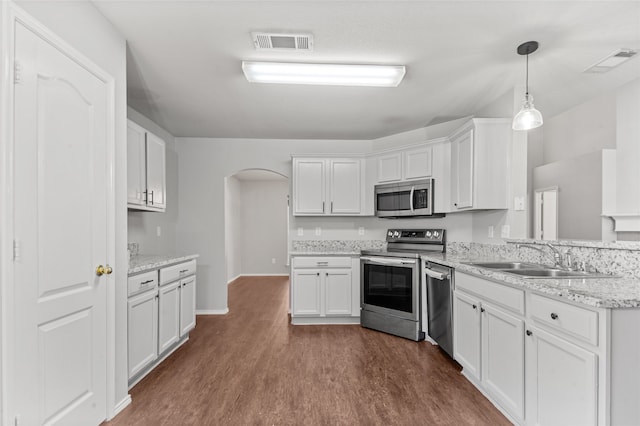 kitchen featuring dark hardwood / wood-style flooring, appliances with stainless steel finishes, white cabinetry, sink, and decorative light fixtures