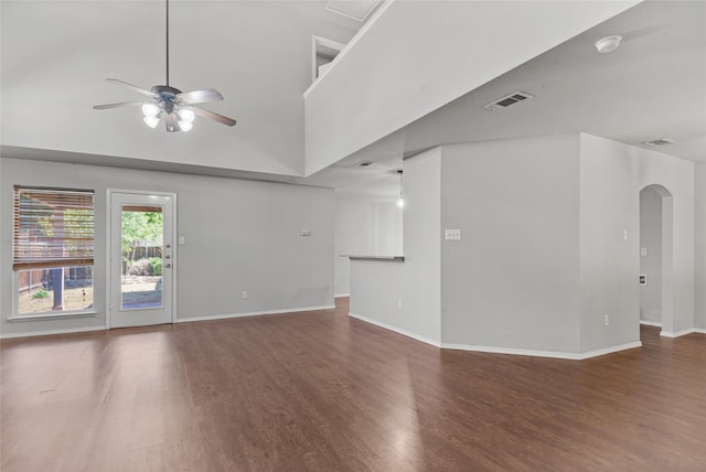 unfurnished room with dark wood-type flooring, a high ceiling, and ceiling fan