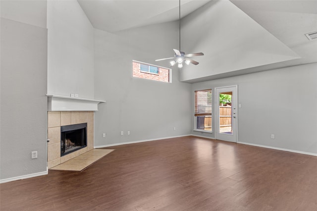 unfurnished living room with ceiling fan, high vaulted ceiling, wood-type flooring, and a fireplace