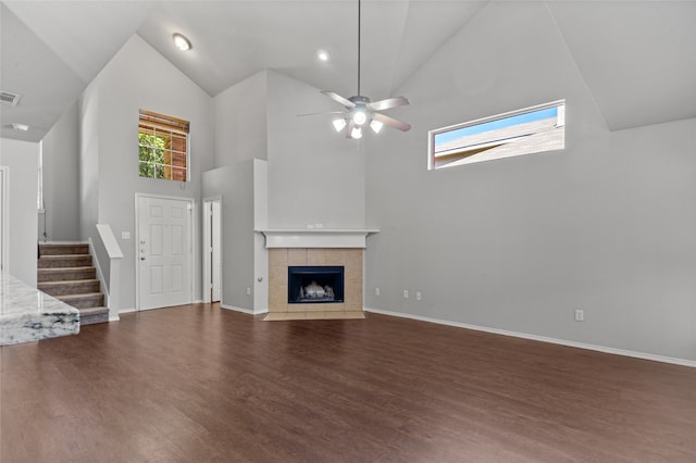 unfurnished living room featuring a fireplace, hardwood / wood-style flooring, high vaulted ceiling, and ceiling fan