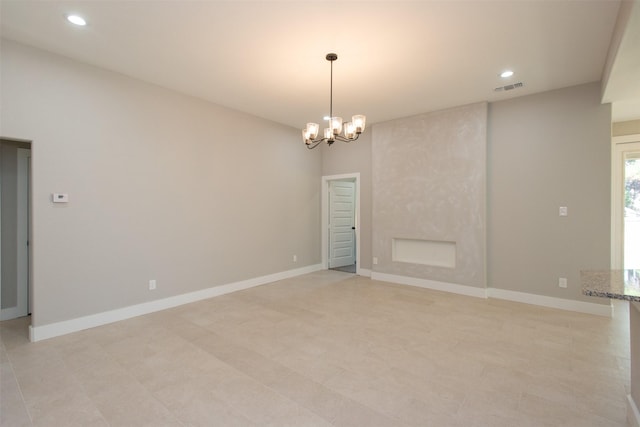 empty room featuring an inviting chandelier and a fireplace