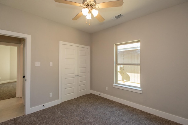 unfurnished bedroom featuring multiple windows, carpet floors, and a closet