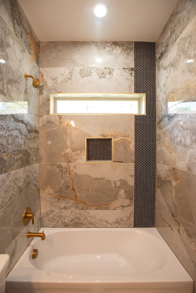 bathroom featuring tiled shower / bath