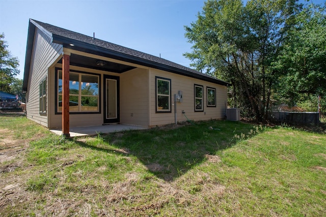 rear view of house with central AC, a yard, and a patio