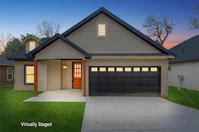 view of front of home with a garage and a lawn