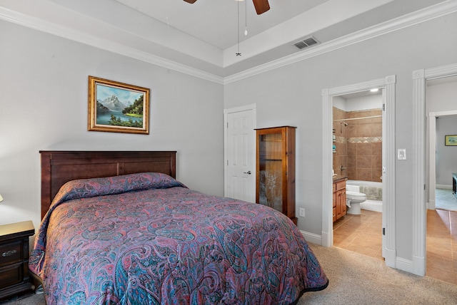 bedroom with ornamental molding, ensuite bath, light colored carpet, and ceiling fan