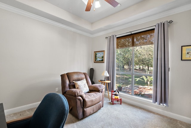 living area with crown molding, carpet floors, and ceiling fan