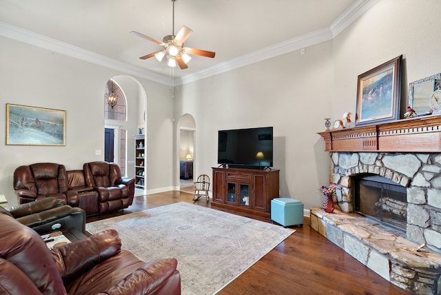 living room featuring crown molding, a fireplace, dark hardwood / wood-style floors, and ceiling fan