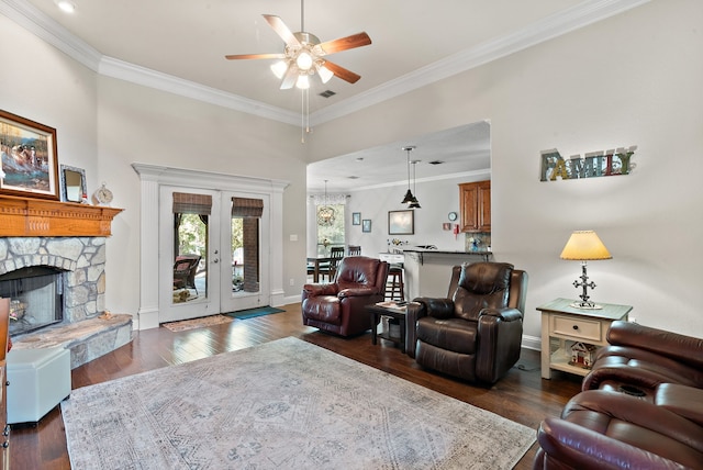 living room featuring ceiling fan, a fireplace, ornamental molding, and dark hardwood / wood-style floors