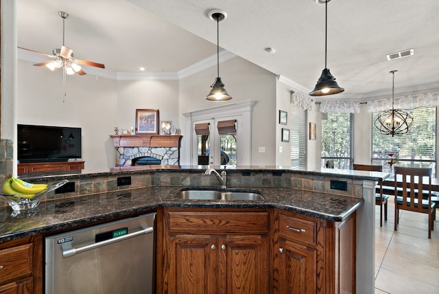 kitchen featuring dishwasher, sink, a fireplace, and pendant lighting