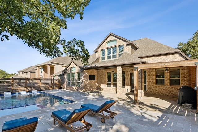 rear view of property featuring a patio, a fenced in pool, and ceiling fan