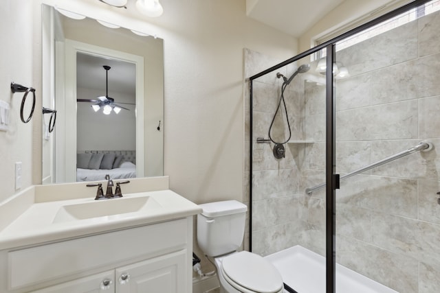 bathroom with ceiling fan, toilet, a shower with door, and vanity