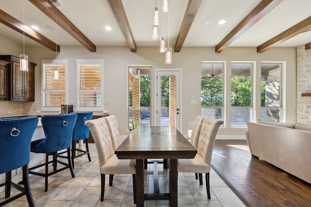 dining room with beamed ceiling and light hardwood / wood-style flooring