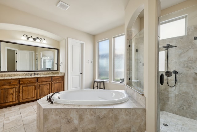 bathroom featuring tile patterned flooring, shower with separate bathtub, and vanity