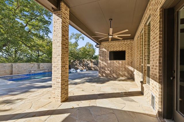 view of patio featuring ceiling fan and a fenced in pool