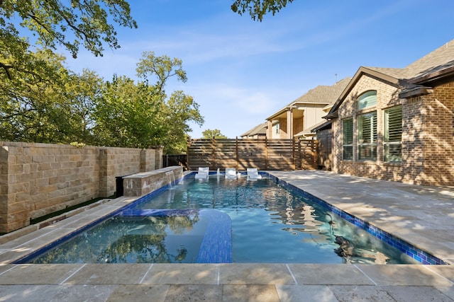 view of pool featuring pool water feature and a patio