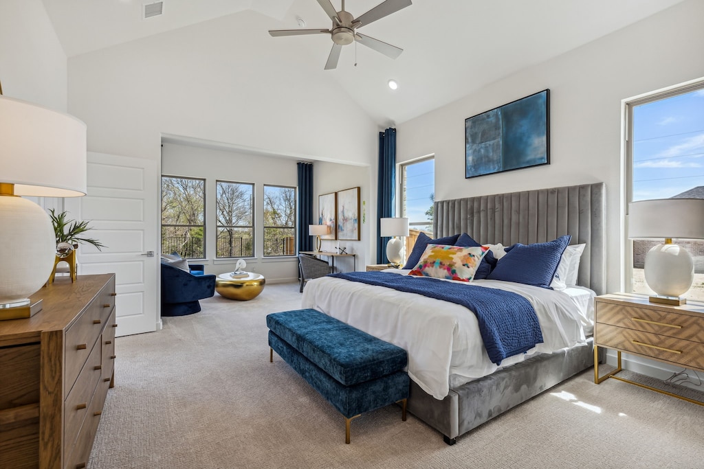 carpeted bedroom with multiple windows, high vaulted ceiling, and ceiling fan