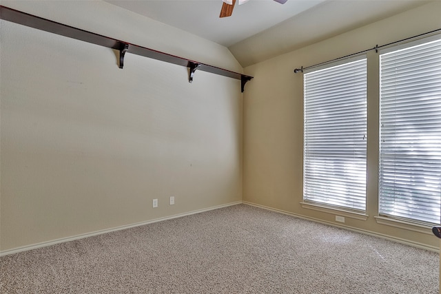 carpeted spare room featuring ceiling fan and lofted ceiling