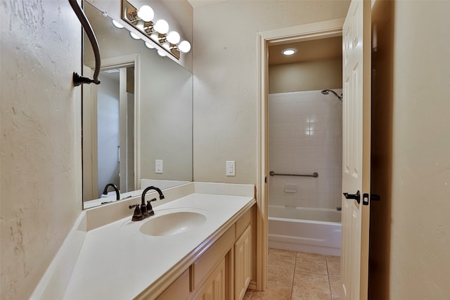 bathroom featuring tiled shower / bath, vanity, and tile patterned floors