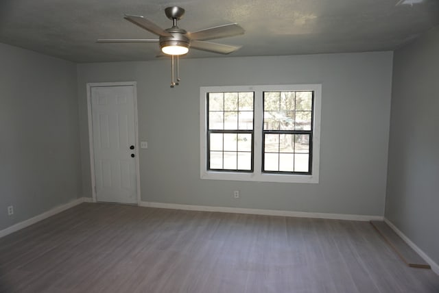 spare room featuring ceiling fan, wood-type flooring, and a textured ceiling