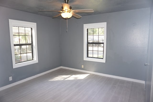 unfurnished room with ceiling fan, hardwood / wood-style flooring, and a textured ceiling