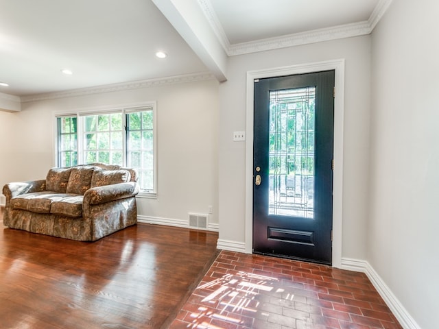 foyer with crown molding, dark hardwood / wood-style floors, and a healthy amount of sunlight