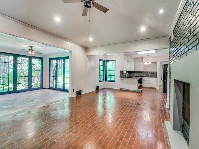 unfurnished living room with crown molding, french doors, and ceiling fan