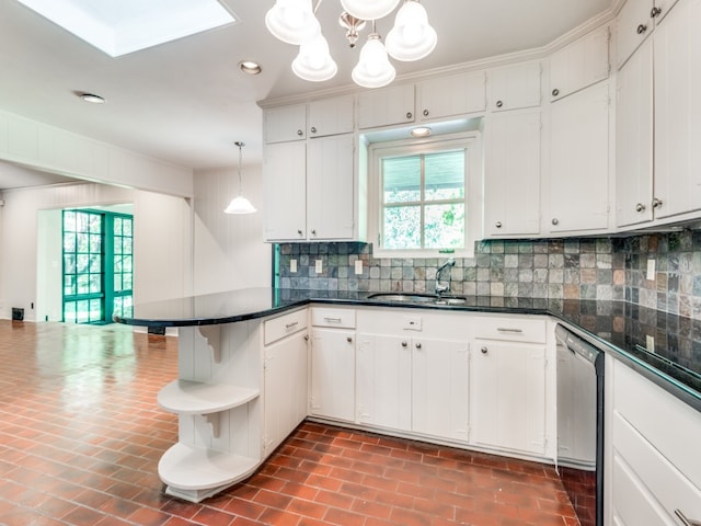 kitchen featuring white cabinets, decorative backsplash, dishwasher, and hanging light fixtures