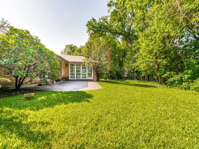 view of yard featuring a patio and french doors