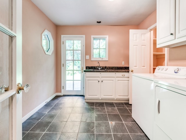 washroom with sink, washer and dryer, and cabinets