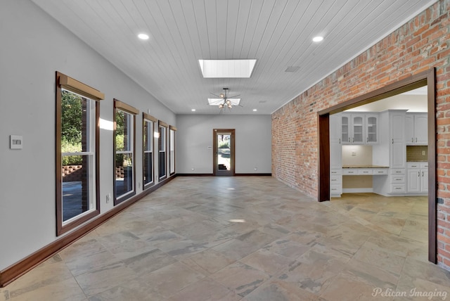 corridor with wood ceiling, brick wall, and a skylight