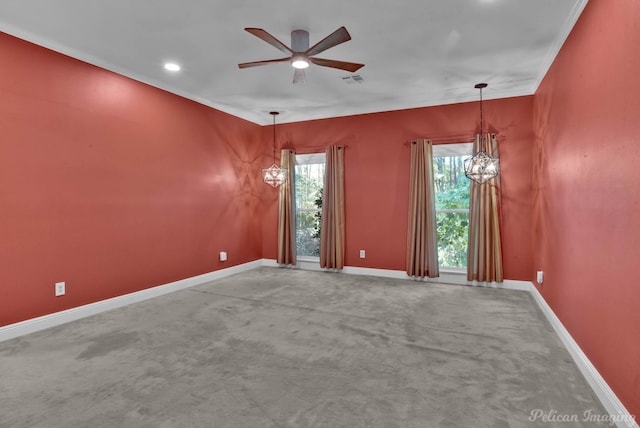 spare room featuring ornamental molding, carpet floors, and ceiling fan with notable chandelier