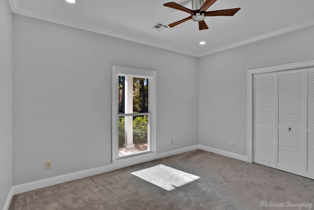 unfurnished bedroom with ornamental molding, light colored carpet, ceiling fan, and a closet